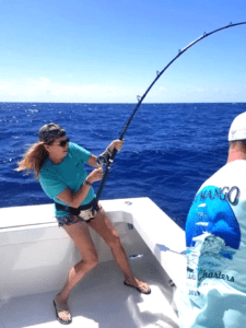 A woman is holding on to a fishing rod